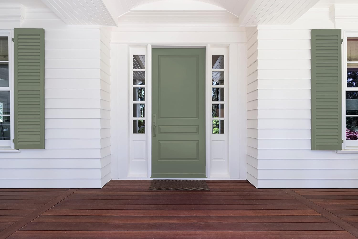 A front entrance featuring a green door flanked by white shutters, with large glass panes on either side, set against a crisp white exterior. The porch has a rich wooden floor, creating a welcoming atmosphere.