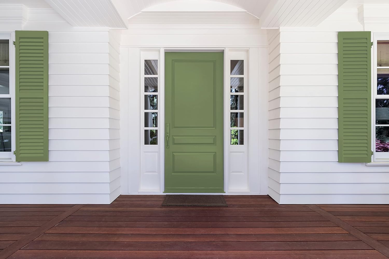 A bright green front door centered between white shutters on either side, framed by white siding and large glass panels. A wooden porch with rich brown planks adds warmth to the entryway.